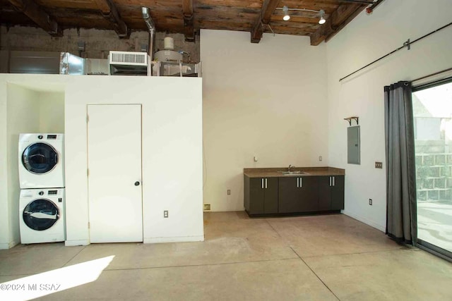 laundry room with stacked washer / dryer, electric panel, and sink