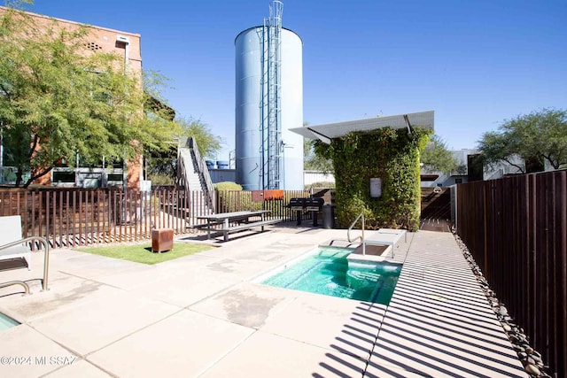 view of swimming pool featuring an in ground hot tub and a patio