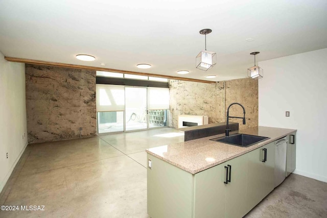 kitchen with sink, a fireplace, kitchen peninsula, hanging light fixtures, and stainless steel dishwasher