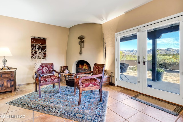 living area with tile patterned flooring, a mountain view, and a large fireplace