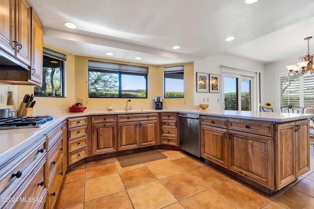 kitchen featuring hanging light fixtures, light tile patterned flooring, appliances with stainless steel finishes, and kitchen peninsula