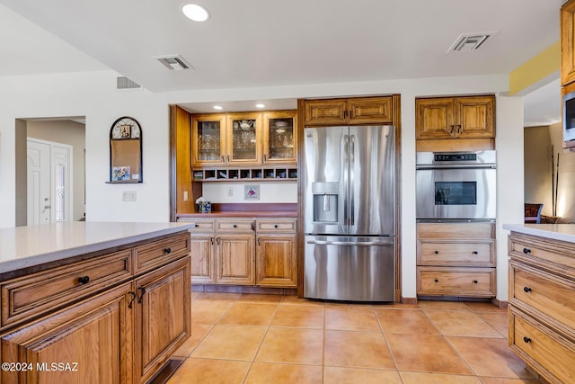 kitchen featuring stainless steel appliances and light tile patterned flooring