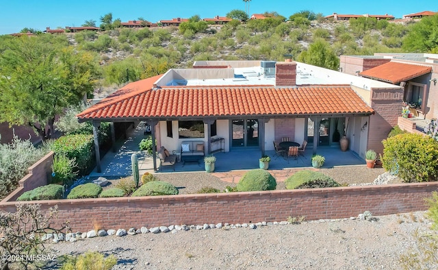 rear view of property with central AC unit and a patio area