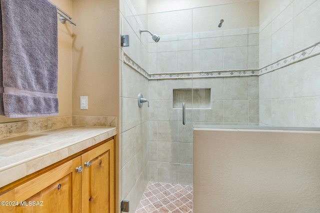 bathroom featuring a shower with door and vanity