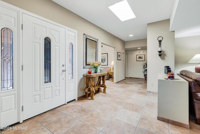 entryway with a skylight and light tile patterned floors