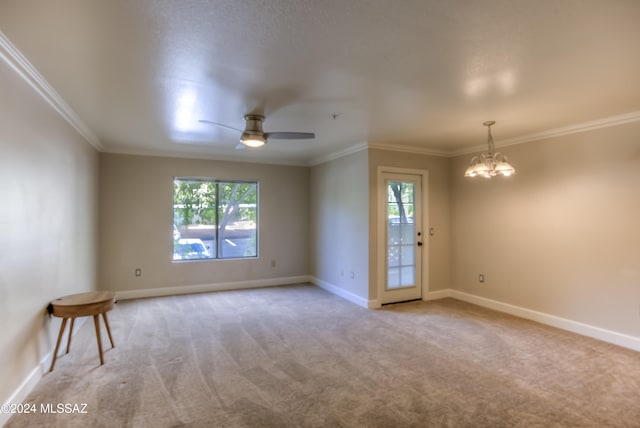 carpeted empty room featuring ornamental molding and ceiling fan with notable chandelier