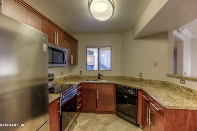 kitchen with kitchen peninsula, sink, light stone countertops, light tile patterned floors, and appliances with stainless steel finishes