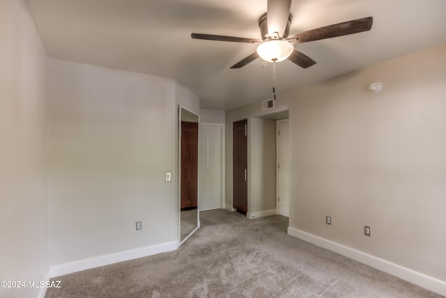 carpeted spare room with ceiling fan