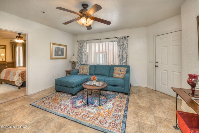 living room with ceiling fan and a textured ceiling