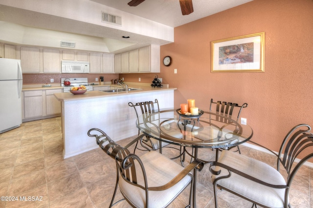 dining room with ceiling fan and sink