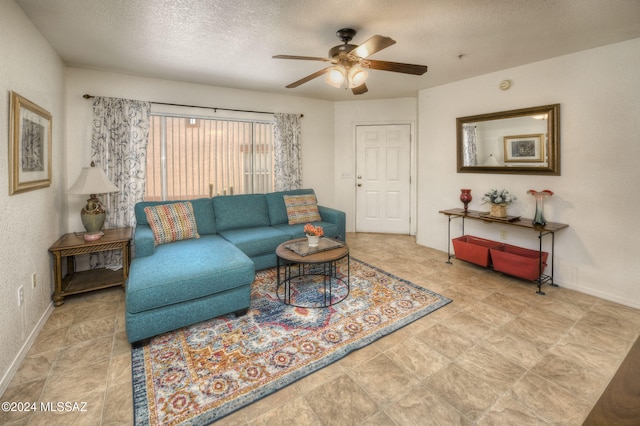 living room with ceiling fan and a textured ceiling