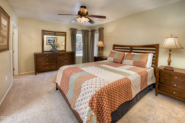 carpeted bedroom with ceiling fan and a textured ceiling