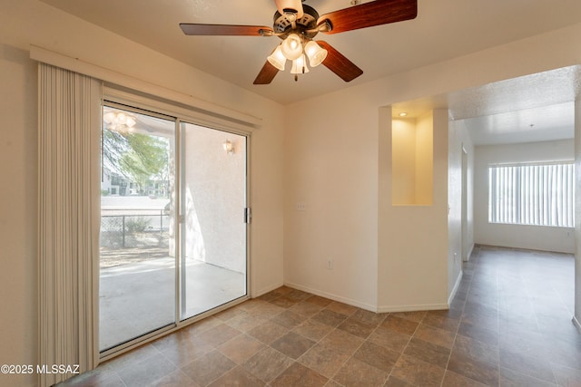 spare room featuring baseboards and a ceiling fan