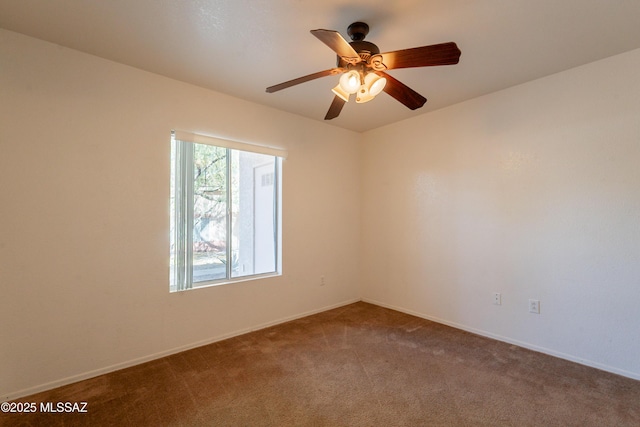 carpeted spare room with baseboards and ceiling fan