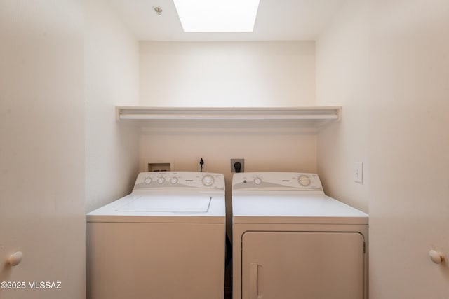 clothes washing area with separate washer and dryer, a skylight, and laundry area
