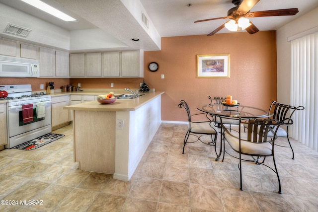 kitchen with ceiling fan, sink, kitchen peninsula, cream cabinets, and white appliances