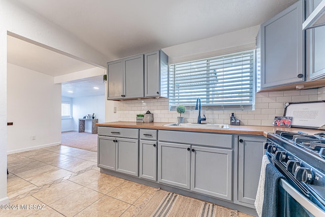 kitchen featuring butcher block counters, gray cabinetry, sink, tasteful backsplash, and light tile patterned flooring