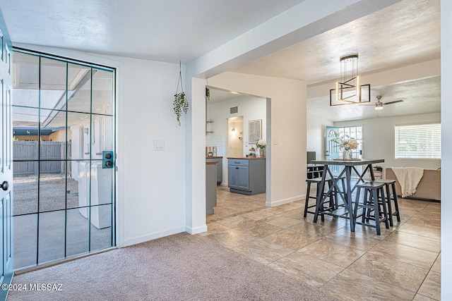 carpeted dining space featuring a textured ceiling and ceiling fan