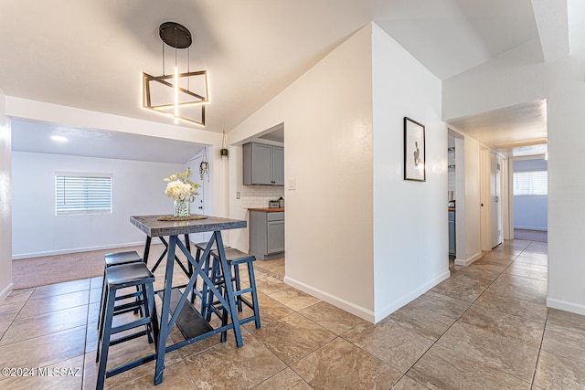 dining room with light tile patterned floors and lofted ceiling