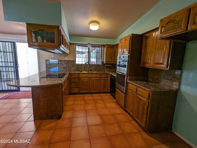 kitchen with black electric stovetop, lofted ceiling, decorative backsplash, sink, and stainless steel double oven