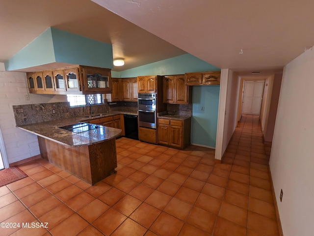 kitchen with kitchen peninsula, black appliances, sink, and light tile patterned floors