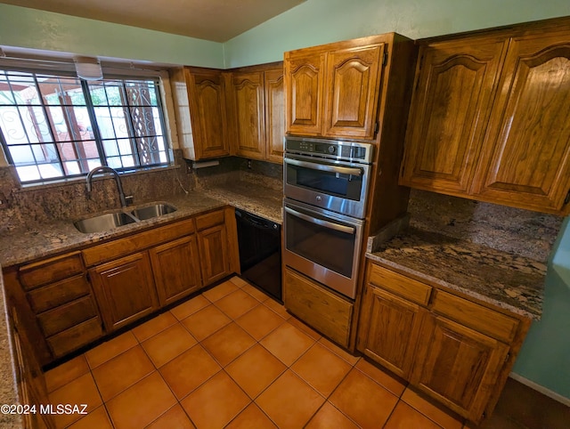 kitchen with vaulted ceiling, dishwasher, sink, light tile patterned floors, and stainless steel double oven