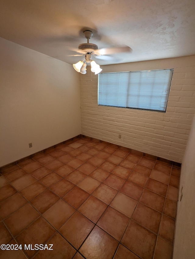 unfurnished room with brick wall and ceiling fan