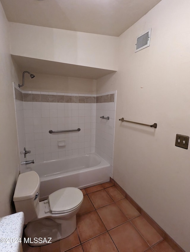 bathroom featuring tile patterned floors, toilet, and tiled shower / bath combo