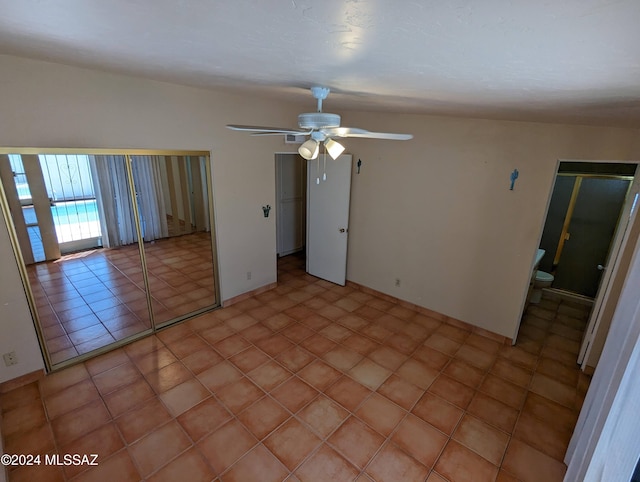 unfurnished bedroom with ceiling fan, ensuite bath, and light tile patterned floors