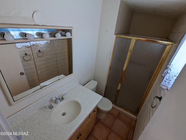 bathroom featuring vanity, tile patterned floors, toilet, and a shower with shower door