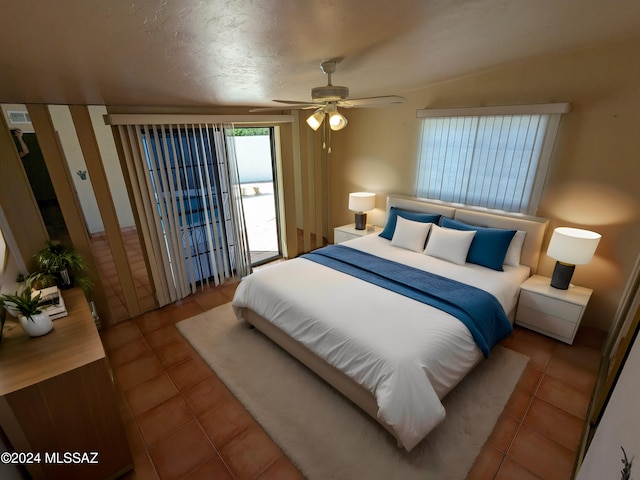 tiled bedroom with ceiling fan, a textured ceiling, and vaulted ceiling