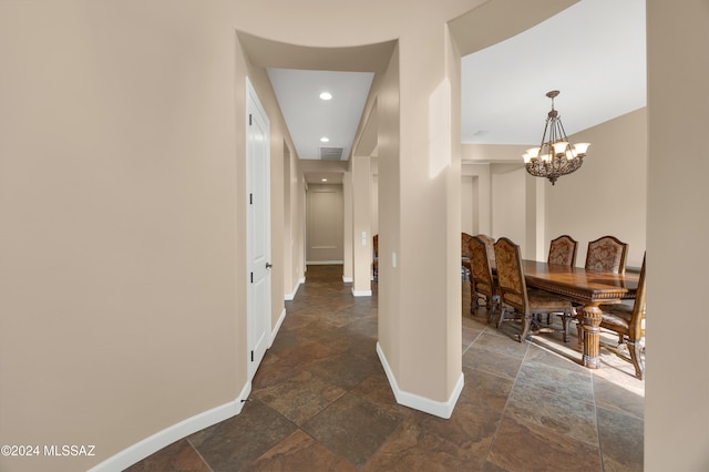 hall with an inviting chandelier