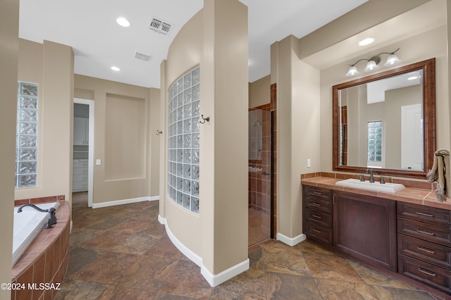 bathroom featuring separate shower and tub and vanity