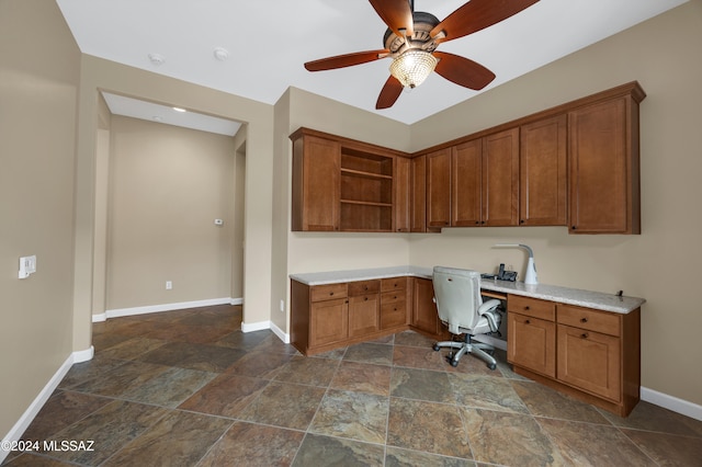 unfurnished office featuring ceiling fan and built in desk