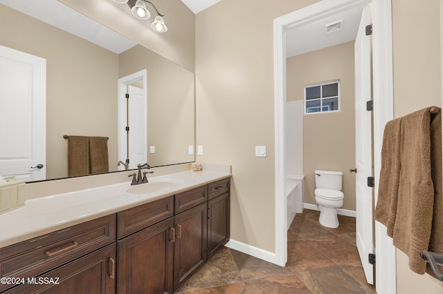 bathroom featuring a washtub, vanity, and toilet