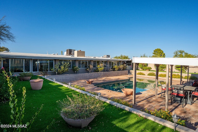 view of pool featuring a patio and a yard