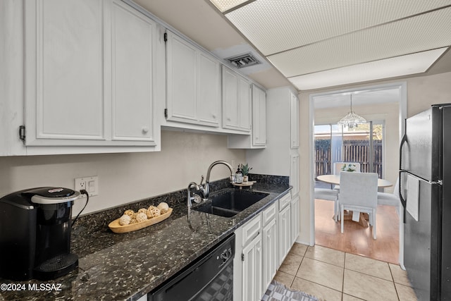 kitchen featuring dark stone counters, black appliances, white cabinets, sink, and light tile patterned floors