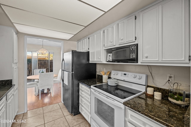 kitchen featuring dark stone counters, a chandelier, white cabinets, black appliances, and light wood-type flooring