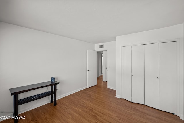 unfurnished bedroom featuring a closet and light wood-type flooring