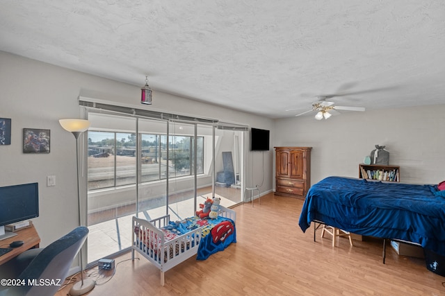 bedroom featuring hardwood / wood-style floors, ceiling fan, and a textured ceiling