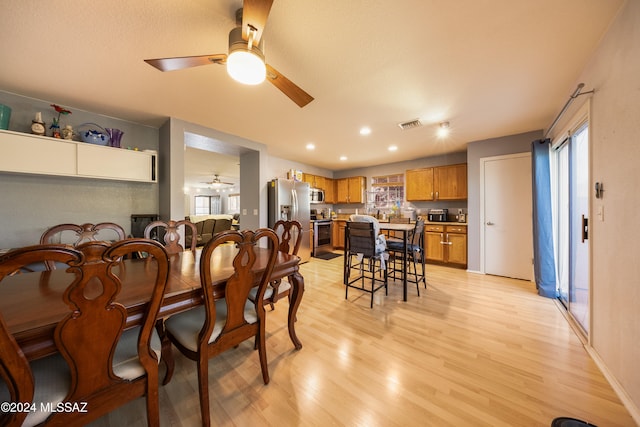 dining area with ceiling fan and light hardwood / wood-style floors