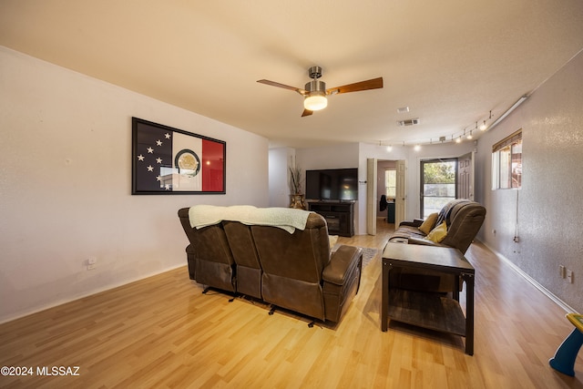 living room featuring light hardwood / wood-style flooring and ceiling fan