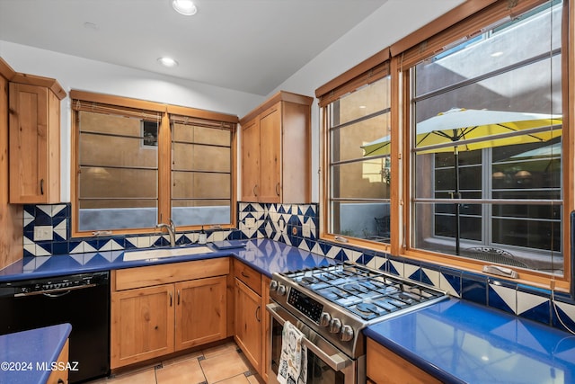 kitchen with dishwasher, backsplash, sink, and range with two ovens