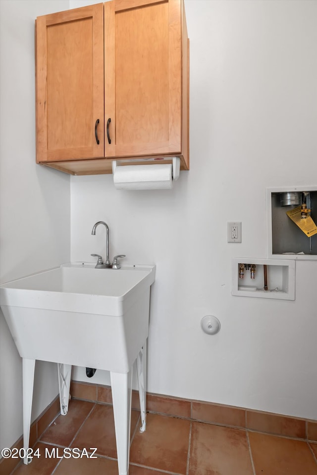 washroom with washer hookup, cabinets, and tile patterned floors