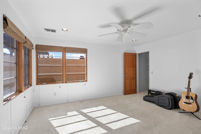 unfurnished room with ceiling fan and light carpet