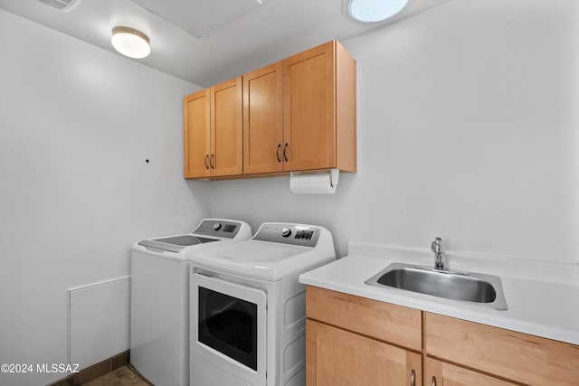 washroom featuring cabinets, washer and clothes dryer, and sink