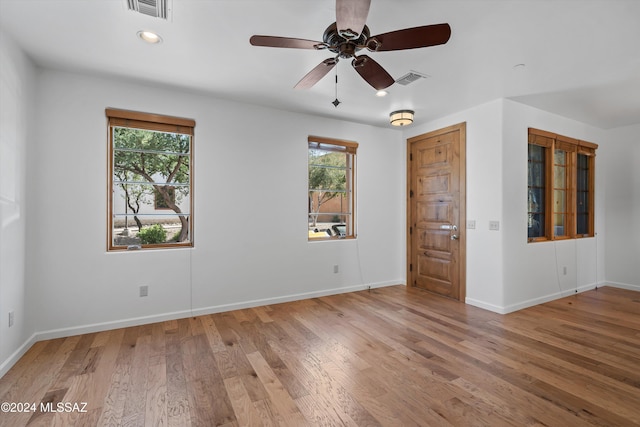 unfurnished room with a wealth of natural light, ceiling fan, and hardwood / wood-style flooring