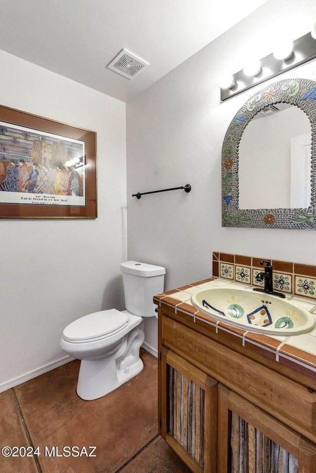 half bath with toilet, baseboards, visible vents, and vanity