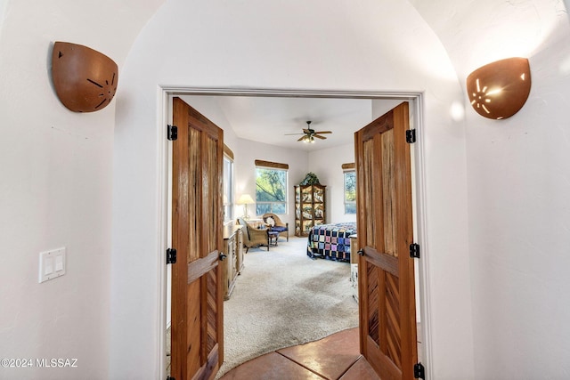 hallway featuring carpet flooring and tile patterned floors