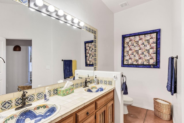 full bathroom featuring visible vents, a sink, toilet, and double vanity